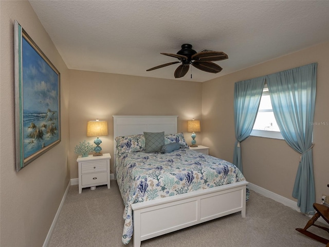 carpeted bedroom with ceiling fan and a textured ceiling