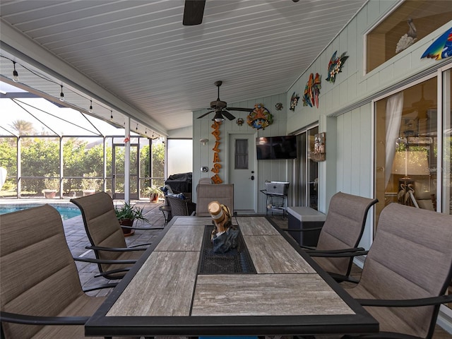 view of patio / terrace with ceiling fan, an outdoor bar, and glass enclosure