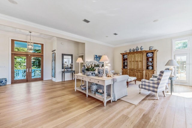 living room featuring crown molding, french doors, and light hardwood / wood-style floors