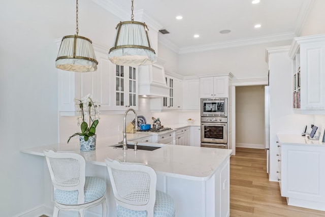 kitchen featuring kitchen peninsula, light hardwood / wood-style flooring, white cabinets, and decorative light fixtures