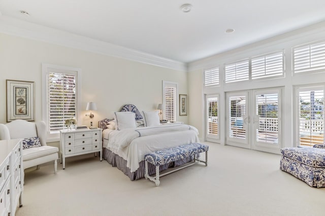 bedroom featuring access to outside, crown molding, french doors, and light colored carpet