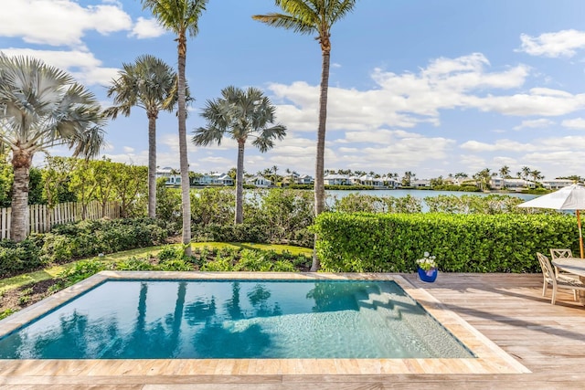 view of swimming pool featuring a water view and a patio area