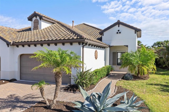 mediterranean / spanish-style home featuring a front yard and a garage