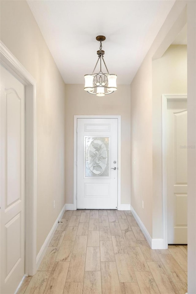 doorway with a chandelier and light hardwood / wood-style floors