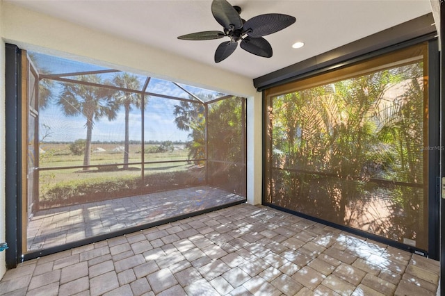 unfurnished sunroom featuring ceiling fan