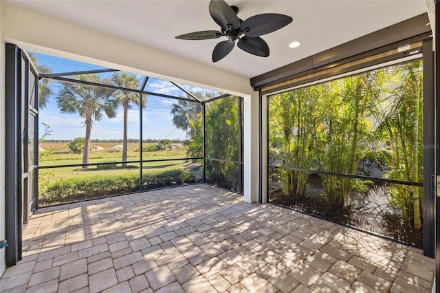 unfurnished sunroom featuring ceiling fan