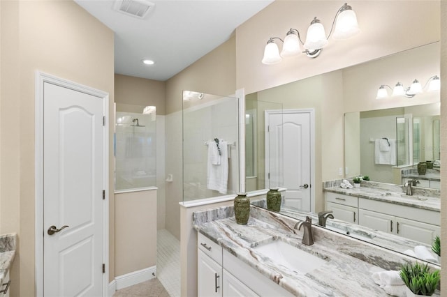 bathroom with a tile shower, tile patterned floors, and vanity