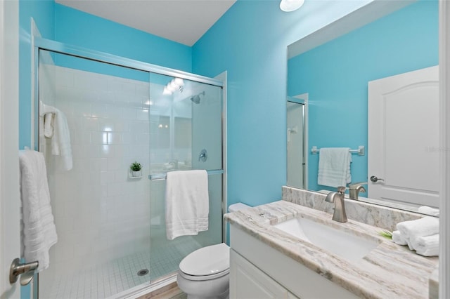 bathroom featuring wood-type flooring, vanity, toilet, and an enclosed shower