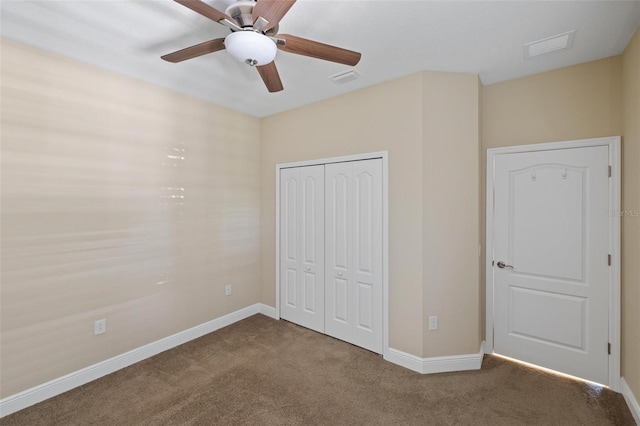 unfurnished bedroom with dark colored carpet, a closet, and ceiling fan