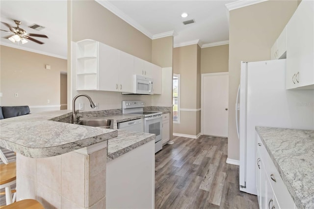 kitchen with kitchen peninsula, a kitchen breakfast bar, white appliances, sink, and light hardwood / wood-style floors