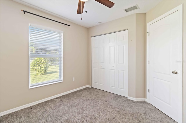 unfurnished bedroom featuring ceiling fan, light carpet, and a closet