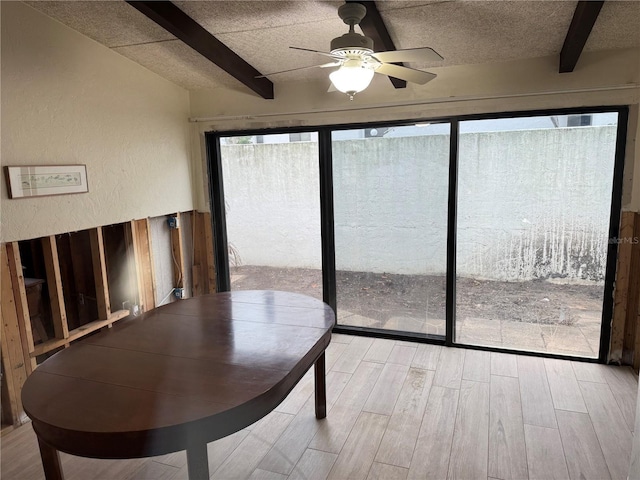 unfurnished sunroom featuring ceiling fan and beamed ceiling