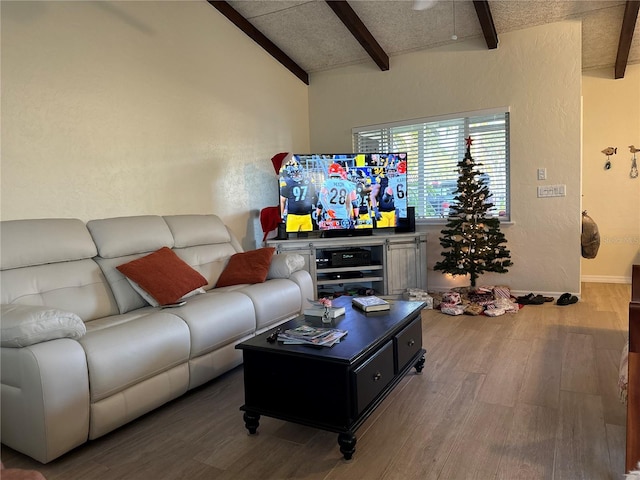 living room featuring vaulted ceiling with beams, hardwood / wood-style floors, and a textured ceiling