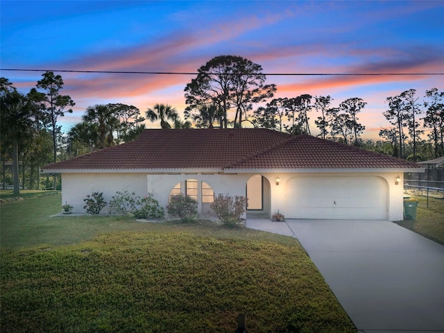 view of front of home featuring a garage and a lawn