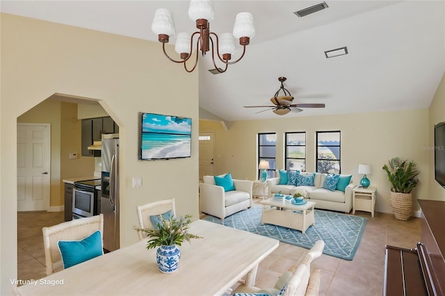 tiled dining room with vaulted ceiling and ceiling fan with notable chandelier