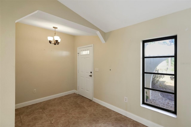 foyer featuring lofted ceiling and an inviting chandelier