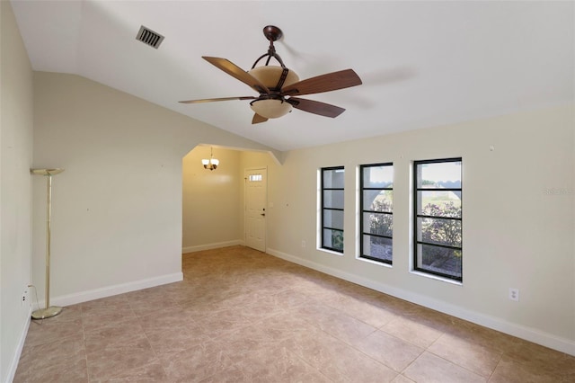 tiled spare room featuring lofted ceiling and ceiling fan with notable chandelier