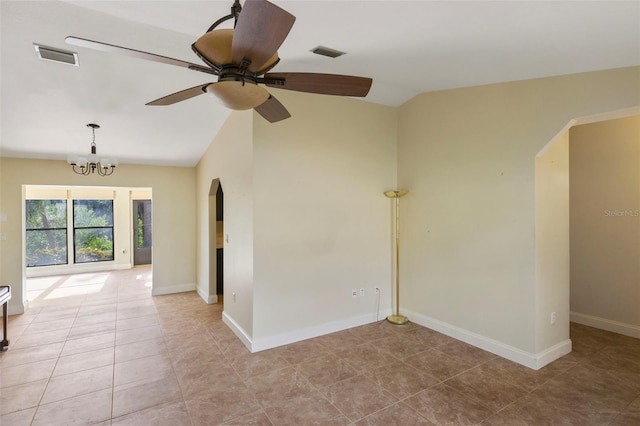 spare room featuring ceiling fan with notable chandelier and vaulted ceiling