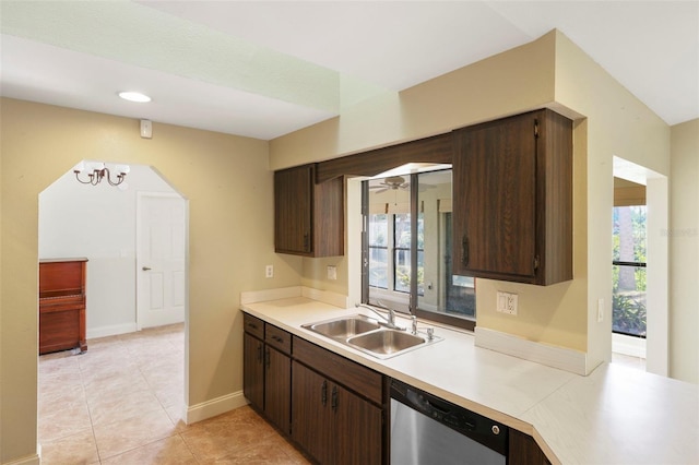 kitchen with dishwasher, sink, light tile patterned flooring, and dark brown cabinetry