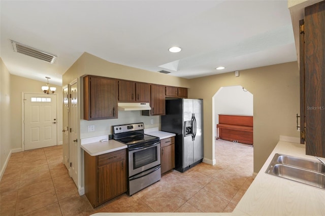 kitchen with light tile patterned floors, sink, stainless steel appliances, vaulted ceiling, and a chandelier