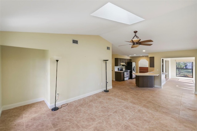 interior space featuring vaulted ceiling with skylight and ceiling fan