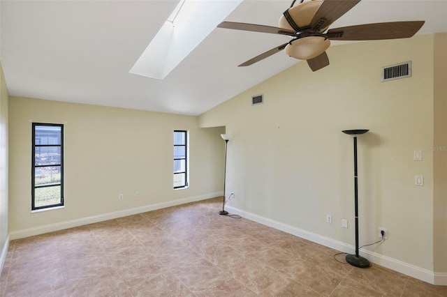 empty room with lofted ceiling with skylight and ceiling fan