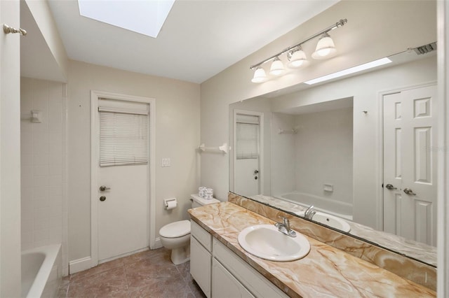 bathroom featuring vanity, toilet, and a skylight