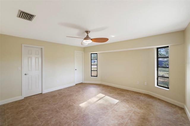 spare room with a wealth of natural light and ceiling fan