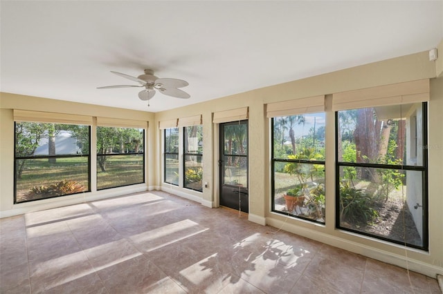 unfurnished sunroom with ceiling fan