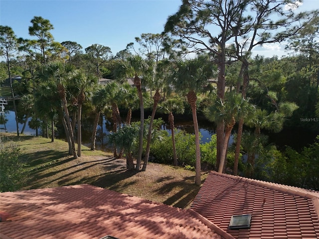 view of community featuring a deck with water view and a yard