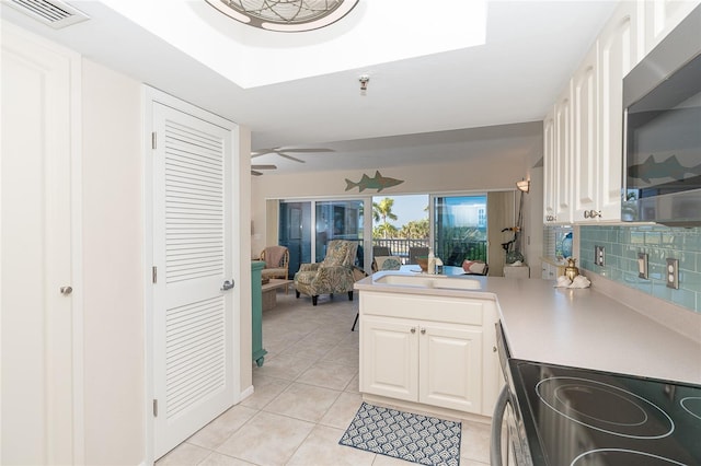 kitchen with ceiling fan, sink, tasteful backsplash, light tile patterned flooring, and range