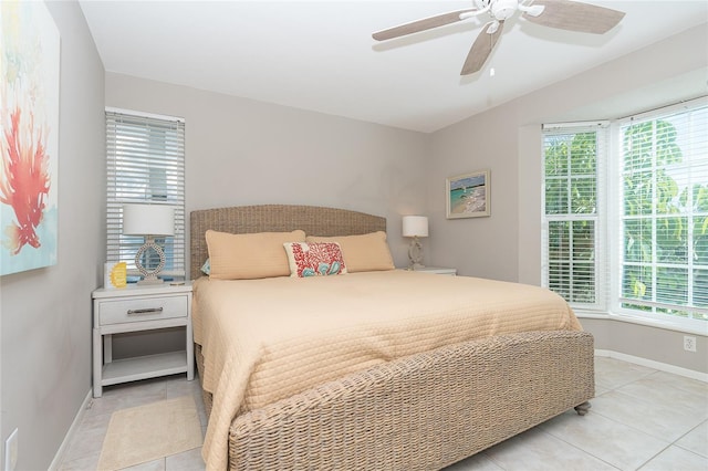 bedroom featuring ceiling fan, light tile patterned floors, and multiple windows