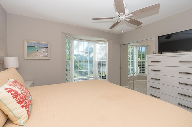 bedroom with multiple windows, ceiling fan, and a closet