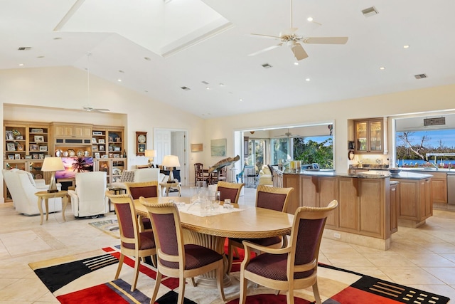 dining area with ceiling fan, light tile patterned floors, and high vaulted ceiling