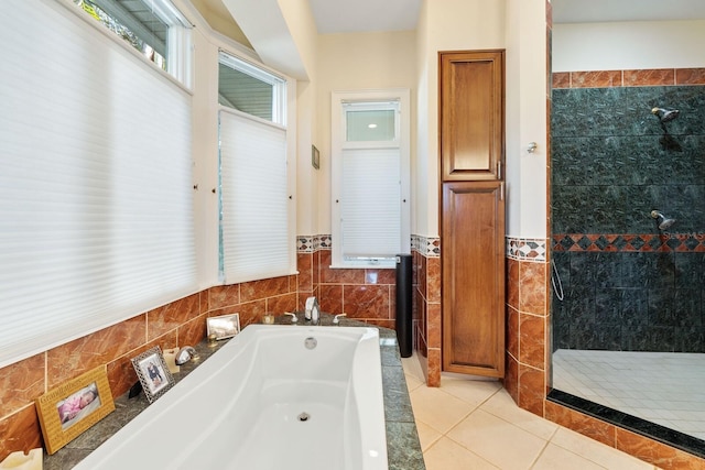 bathroom featuring tile patterned flooring, tile walls, and plus walk in shower