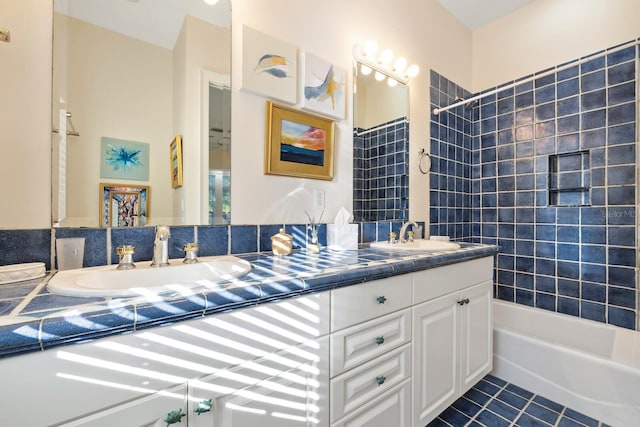 bathroom with tile patterned flooring, vanity, and tiled shower / bath