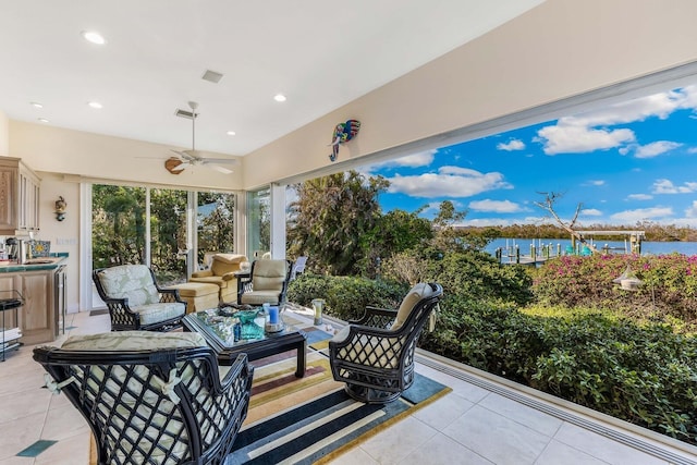 view of patio featuring ceiling fan, a water view, and an outdoor living space