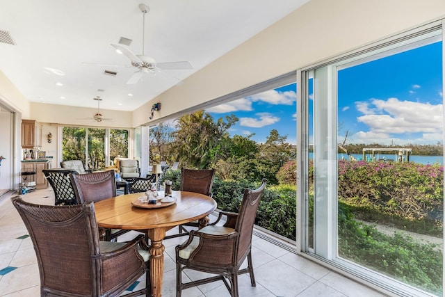 sunroom / solarium with ceiling fan and a water view