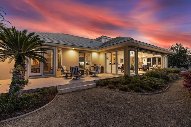 back house at dusk with an outdoor hangout area and a patio area