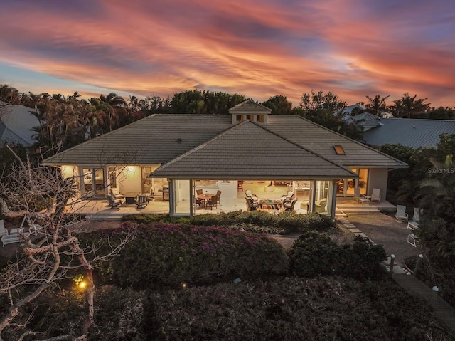 back house at dusk with a patio area