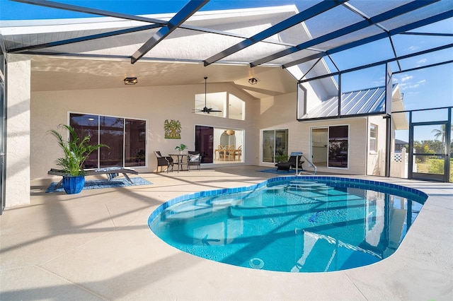 view of swimming pool featuring ceiling fan, glass enclosure, and a patio area