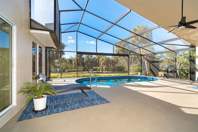 view of pool with glass enclosure and a patio area