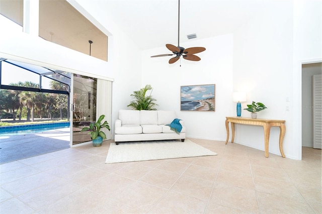 tiled living room featuring ceiling fan and high vaulted ceiling