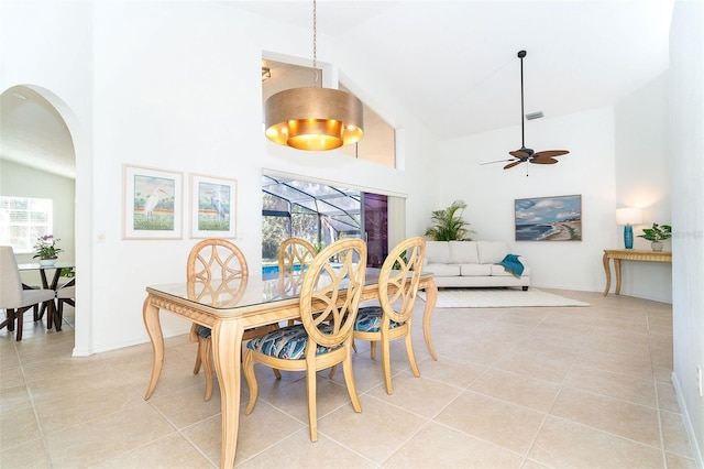 tiled dining space featuring ceiling fan and high vaulted ceiling