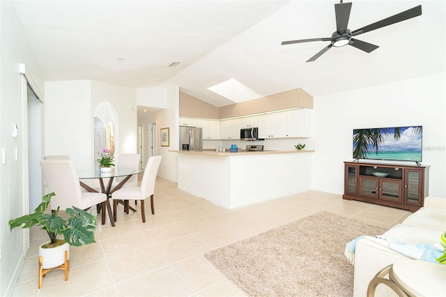 living room with vaulted ceiling, ceiling fan, and light tile patterned flooring