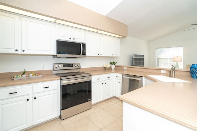 kitchen featuring vaulted ceiling, white cabinetry, sink, kitchen peninsula, and stainless steel appliances