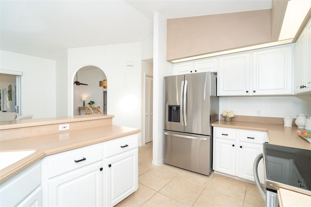 kitchen featuring light tile patterned flooring, vaulted ceiling, white cabinets, ceiling fan, and stainless steel appliances