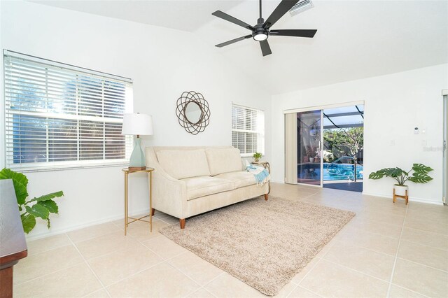 living room featuring lofted ceiling, tile patterned floors, and ceiling fan