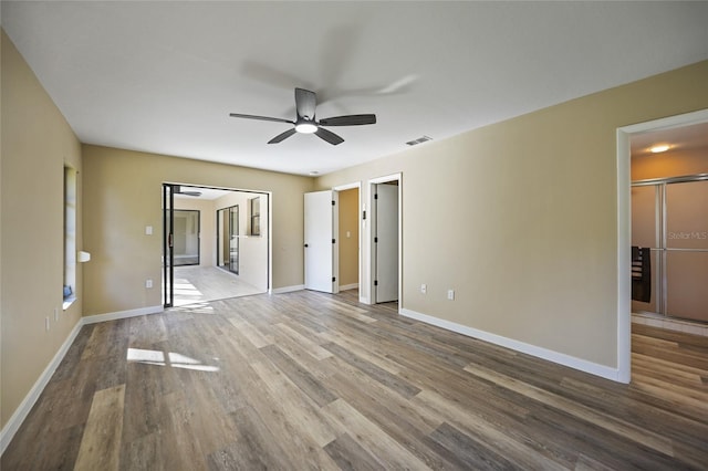 unfurnished bedroom with ensuite bath, ceiling fan, and wood-type flooring