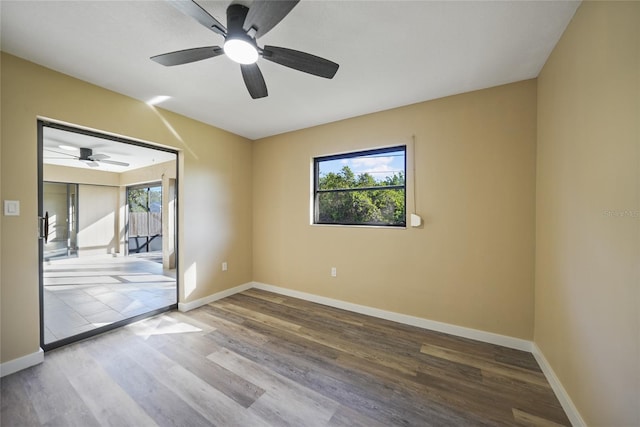 empty room featuring a wealth of natural light, ceiling fan, and wood-type flooring